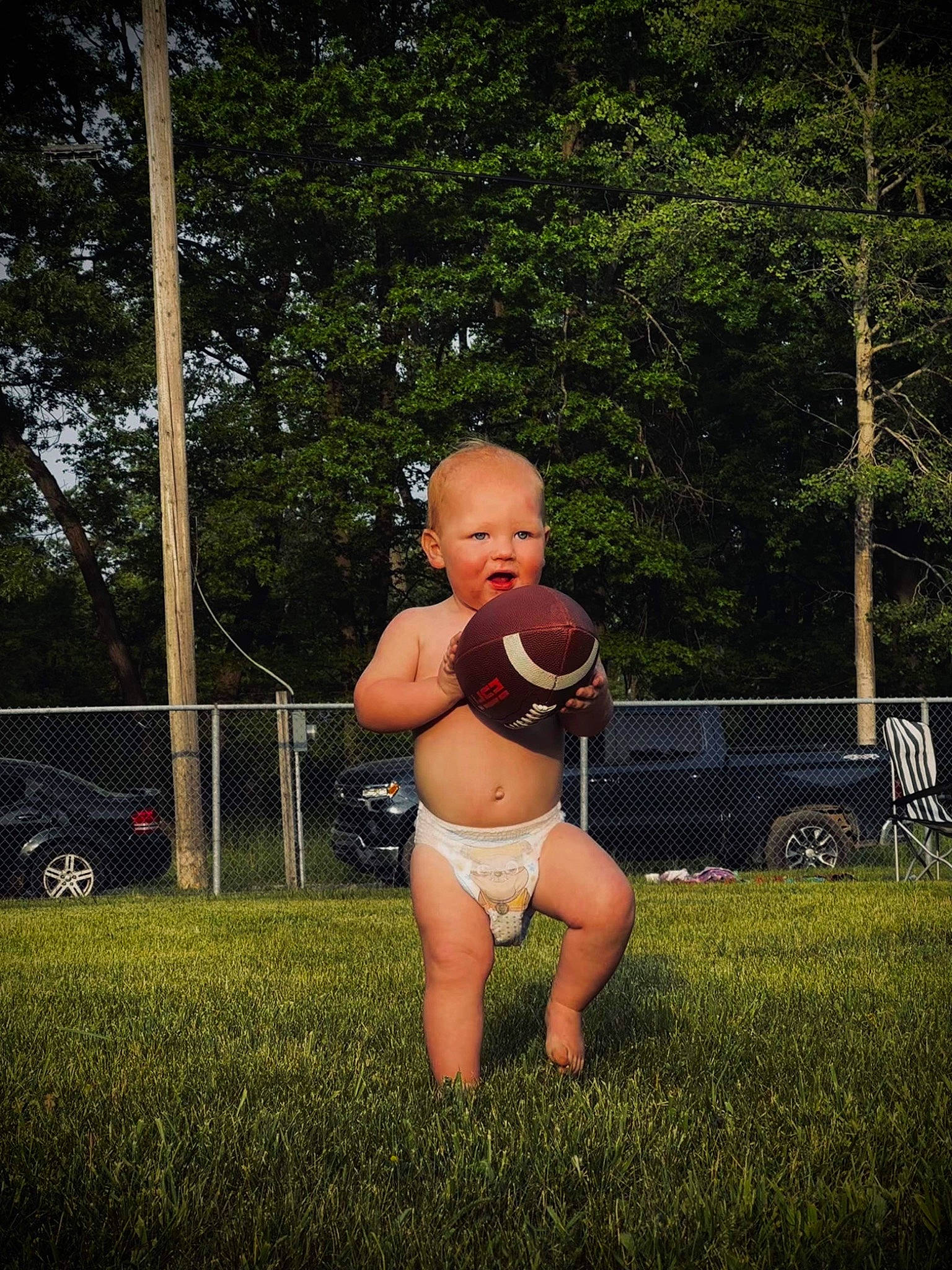 Wyatt is registered to the contest to win money with this photo: abdomen, chest, flash_photography, grass, grass_family, happy, human_leg, lawn, leisure, navel, people_in_nature, person, plant, recreation, swimwear, thigh, tire, toddler, tree, trunk