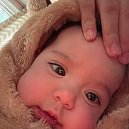 Mia joined the competition — help win amazing prizes! baby, infant, face, eyes, hand, fuzzy_clothing, hood, cute, chubby_cheeks, close_up, indoors, warm, soft_texture, child, person, portrait, cozy, expression, skin, adorable