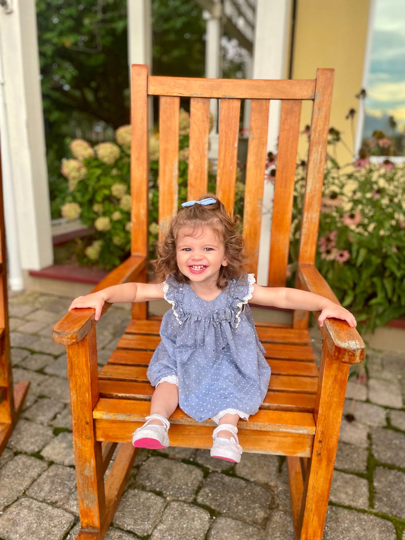 Monroe is registered to the contest to win money with this photo: baby_toddler_clothing, chair, comfort, dress, furniture, grass, happy, head, joy, leg, leisure, magenta, outdoor_furniture, people_in_nature, person, plant, product, skin, smile, toddler