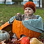 baby, pumpkin, autumn, fall_leaves, gourd, orange_hat, blanket, outdoor, grass, cute, child, seasonal, smiling, nature, cozy, sitting, portrait, leaf_litter, warm_clothing, festive
