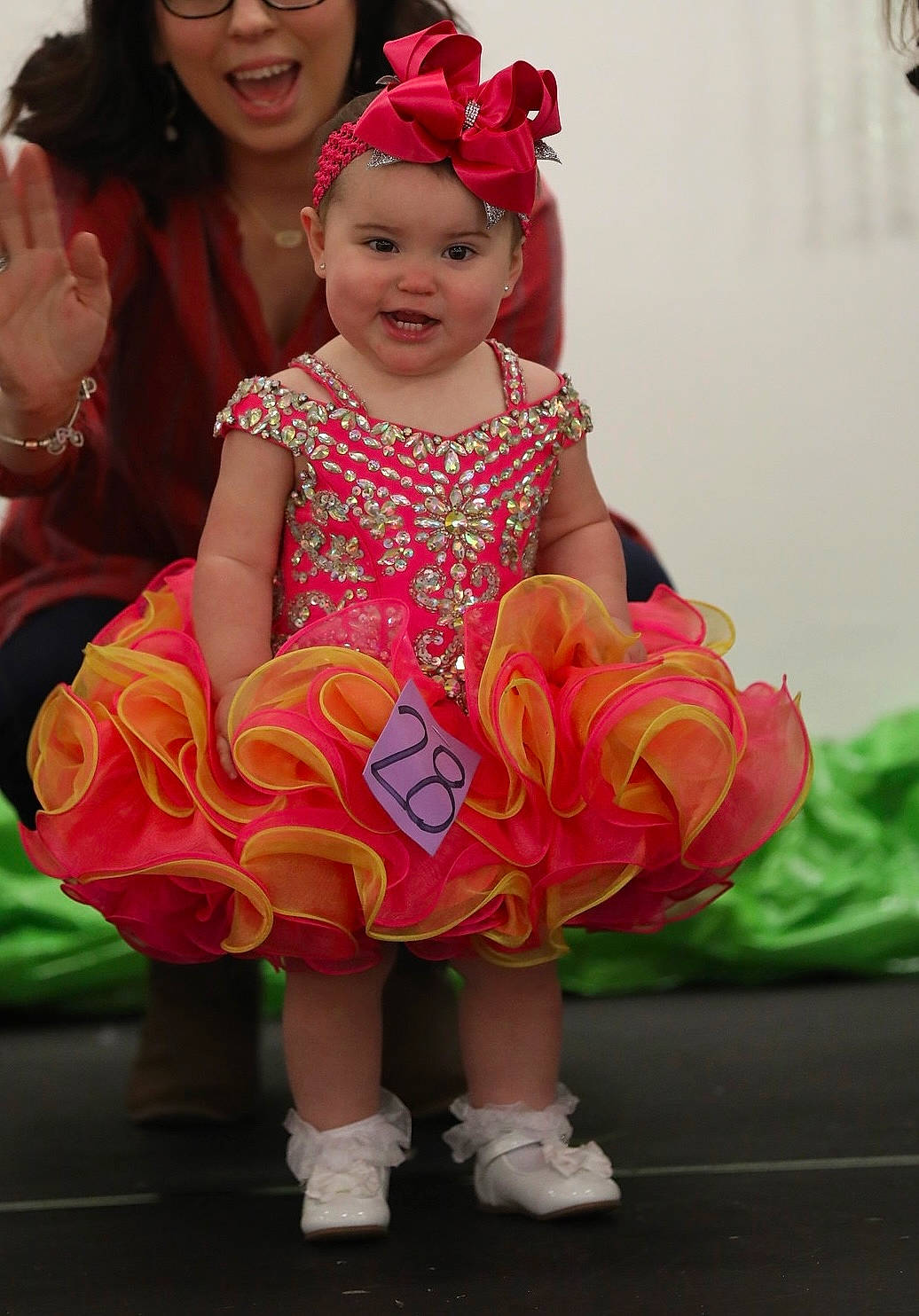 Kara Anne is registered to the contest to win money with this photo: baby_toddler_clothing, child, dress, event, face, fun, grass, happy, hat, headwear, human_body, jewellery, leisure, magenta, person, pink, recreation, red, sandal, smile