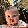 Pearl is registered to the contest to win money with this photo: baby, close_up, drool, pink_clothing, button, outdoor, backyard, brick_wall, fence, plant_pot, curious, face, skin, child, person, summer, sunlight, portrait, head, young