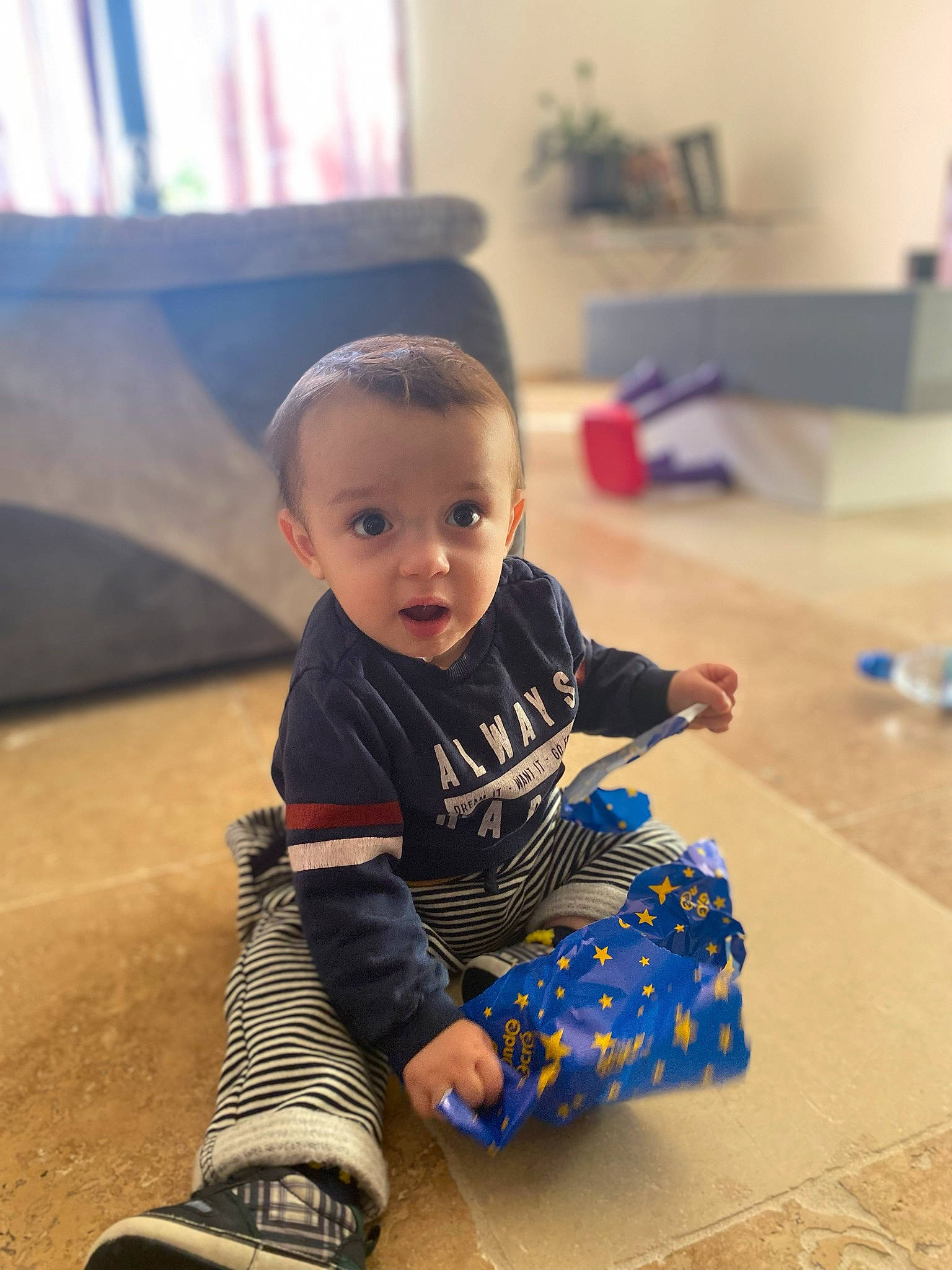 Mylo participe au concours pour gagner de l'argent avec cette photo : baby, baby_toddler_clothing, child, floor, flooring, foot, fun, happy, hardwood, human_leg, knee, leg, leisure, person, play, sitting, sleeve, smile, surprise, t_shirt