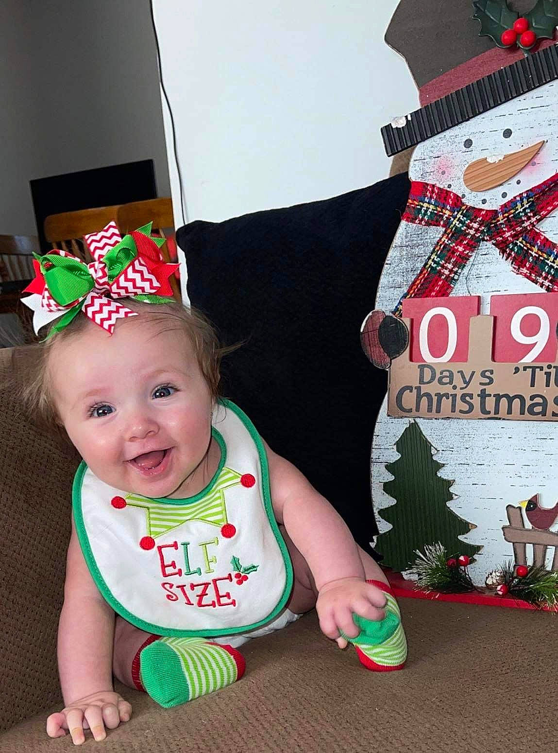 Mallory joined the competition — help win amazing prizes! baby, baby_toddler_clothing, christmas, christmas_eve, costume_hat, event, fashion_accessory, fictional_character, green, happy, hat, headgear, holiday, party_hat, party_supply, person, product, sleeve, smile, sock