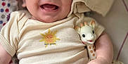 Mattéo a rejoint le concours — aidez-le/la à gagner de superbes lots ! baby, smiling, infant, toy, giraffe, onesie, blanket, pattern, cute, happy, child, face, hand, clothing, soft, lying_down, indoor, closeup, playful, comfort