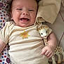 baby, smiling, infant, toy, giraffe, onesie, blanket, pattern, cute, happy, child, face, hand, clothing, soft, lying_down, indoor, closeup, playful, comfort