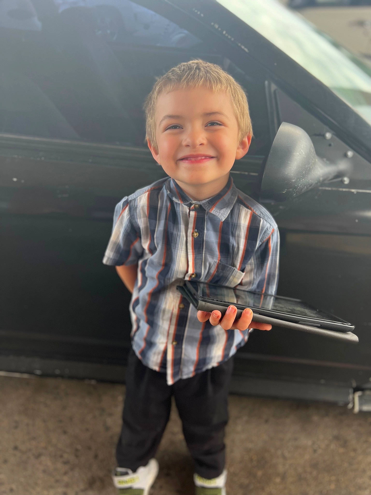 Troy is registered to the contest to win money with this photo: automotive_design, automotive_exterior, automotive_lighting, bumper, car, child, cool, face, flash_photography, happy, joy, motor_vehicle, outerwear, person, personal_luxury_car, plaid, sleeve, smile, t_shirt, toddler