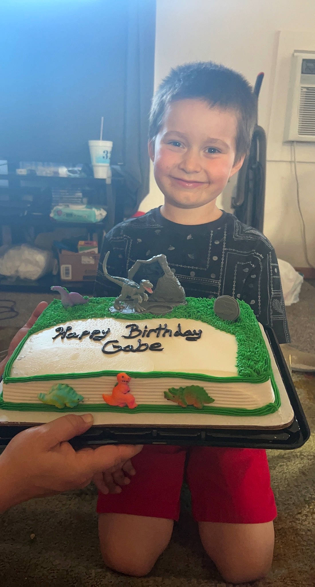 Gabriel is registered to the contest to win money with this photo: baked_goods, birthday_cake, cake, cake_decorating, cake_decorating_supply, chair, cuisine, dessert, electronic_device, food, fun, green, happy, joy, person, sharing, smile, snapshot, sugar_cake, sweetness