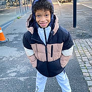 Iliandro participe au concours pour gagner de l'argent avec cette photo : child, boy, smiling, jacket, hoodie, sweatpants, sneakers, sidewalk, urban, street, outdoor, daylight, casual, happy, curly_hair, person, clothing, fashion, posing, city