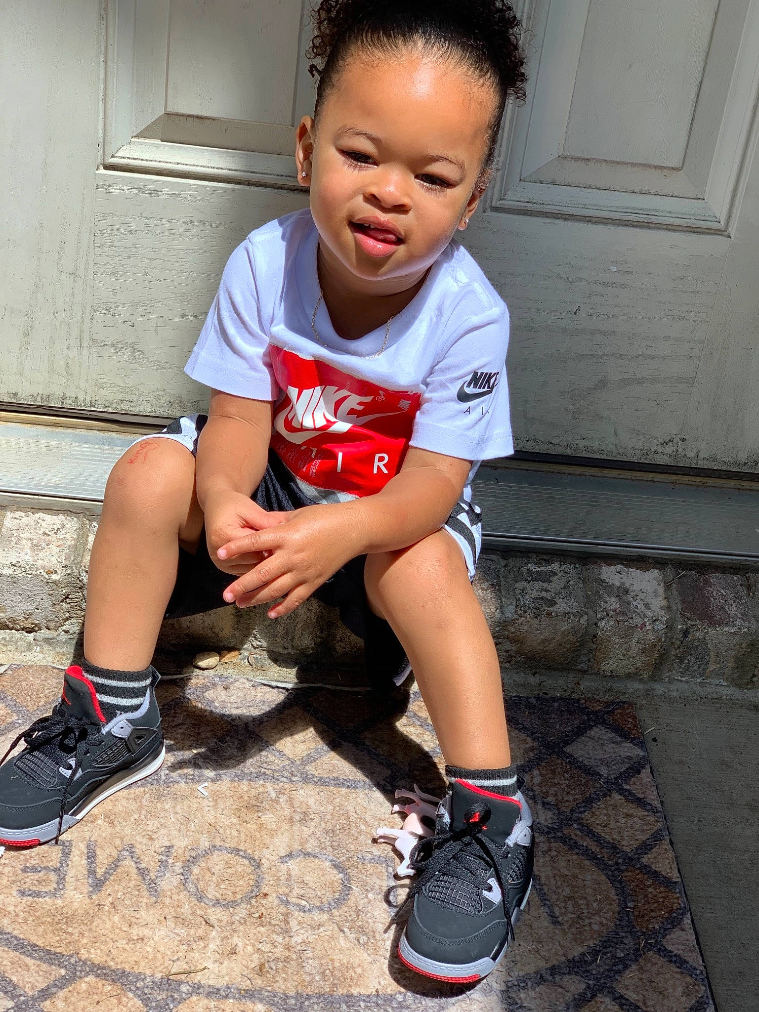 King is registered to the contest to win money with this photo: child, child_model, cool, footwear, fun, human_leg, knee, leg, male, nose, person, play, red, shoe, sitting, skin, smile, t_shirt, toddler, vacation
