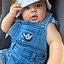 baby, bucket_hat, button, car_seat, child, closeup, clothing, curious, cute, denim_overalls, face, fashion, hand, hat, infant, patch, person, portrait, sitting, skin