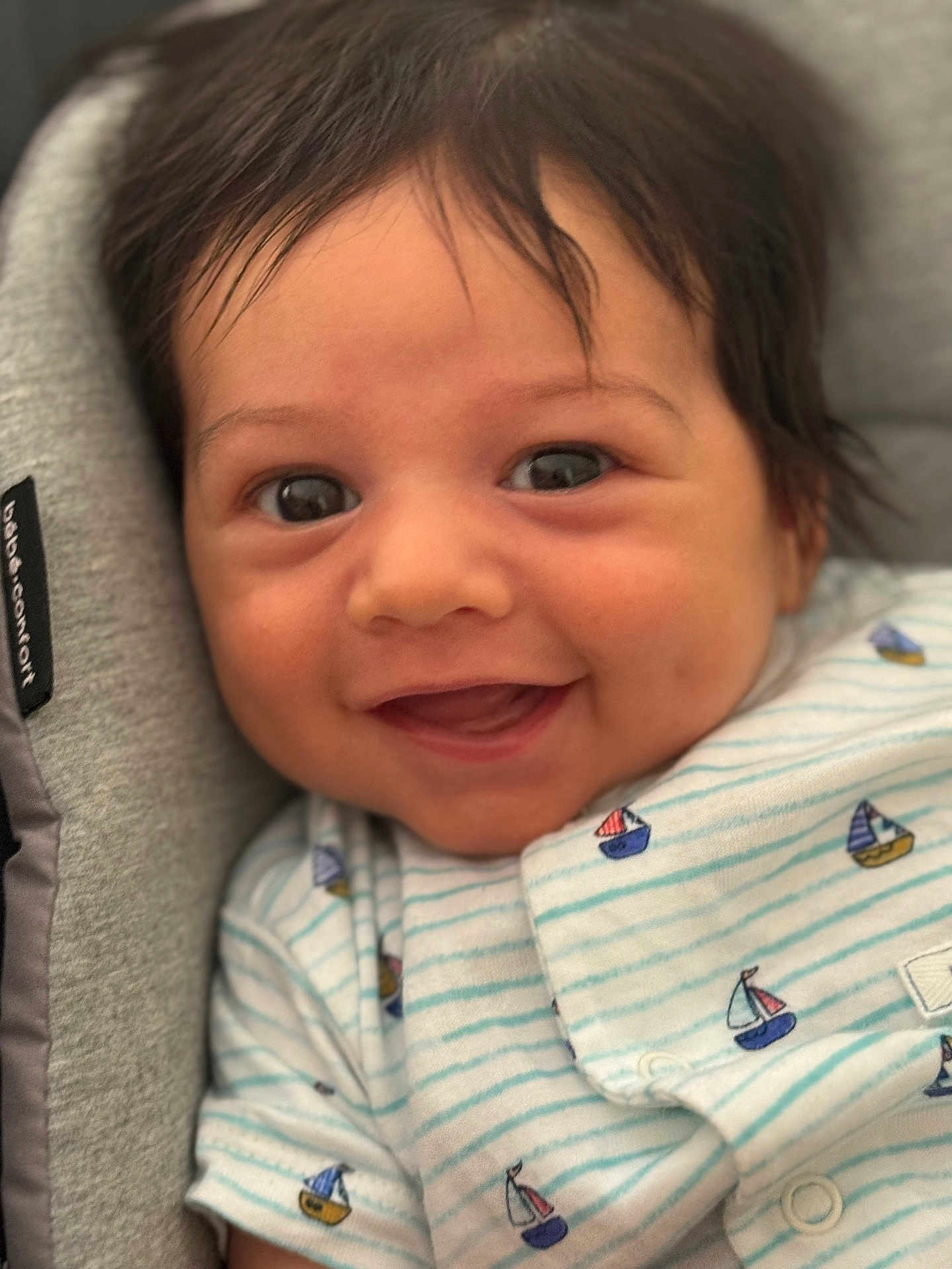 Basile a rejoint le concours — aidez-le/la à gagner de superbes lots ! baby, smiling, close_up, face, infant, happy, clothing, striped, sailboats, cute, child, person, soft, cushion, indoor, portrait, head, eyes, mouth, newborn