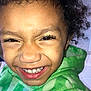 casual_clothing, child, close_up, curly_hair, cute, expression, eyelashes, face, green_hoodie, happy, indoors, joyful, nostrils, person, portrait, skin, smiling, sweatshirt, teeth, young