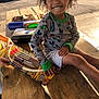 King joined the competition — help win amazing prizes! child, smiling, curly_hair, minecraft_shirt, toy, bow_and_arrow, picnic_table, outdoor, daylight, park, playground, wood, person, happy, casual_clothing, shorts, hand, face, sunlight, recreation