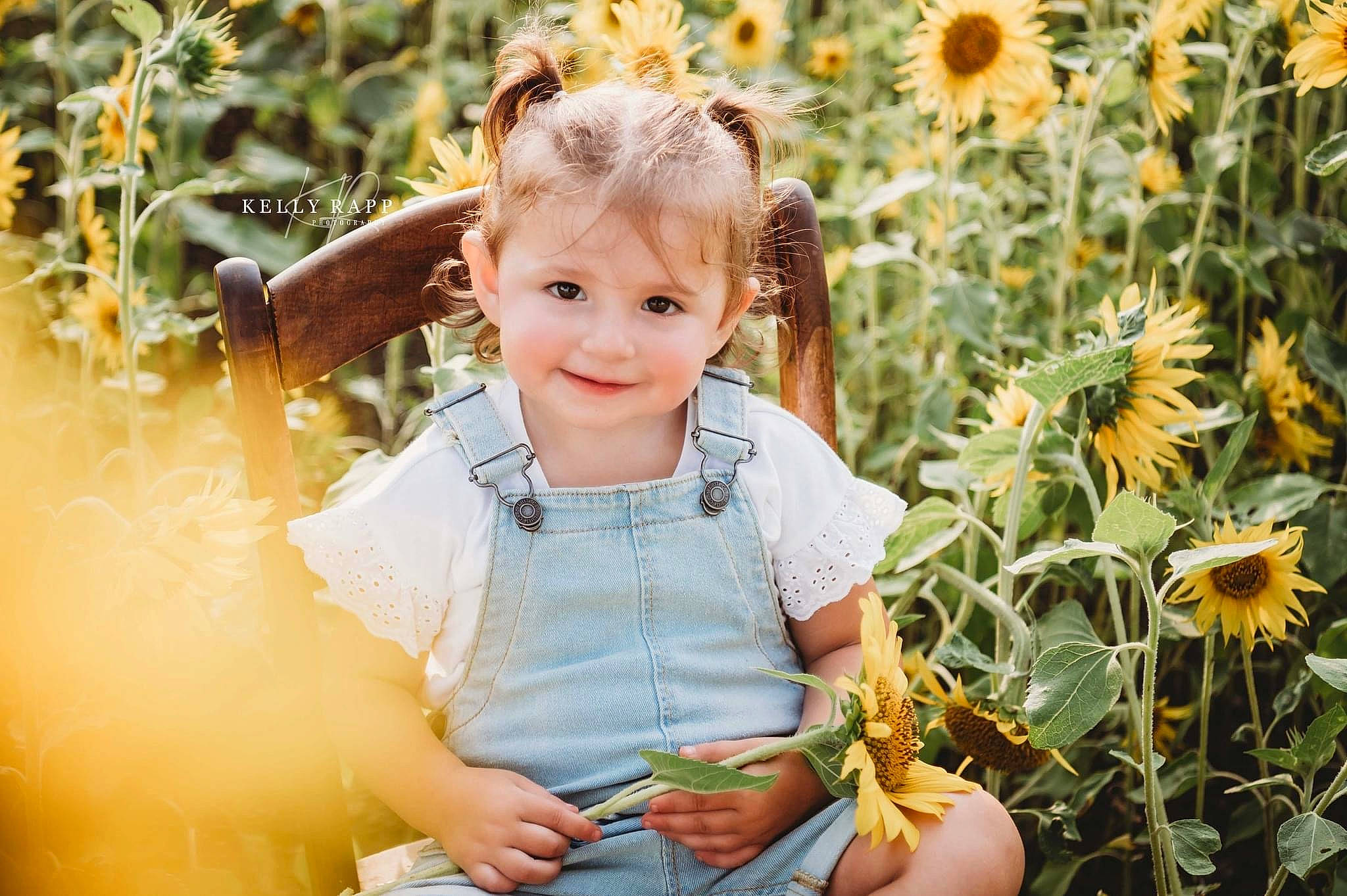 Emberlynn is registered to the contest to win money with this photo: baby_toddler_clothing, botany, flash_photography, flower, grass, green, happy, joy, leaf, light, morning, nature, orange, people_in_nature, person, photograph, plant, smile, summer, sunlight