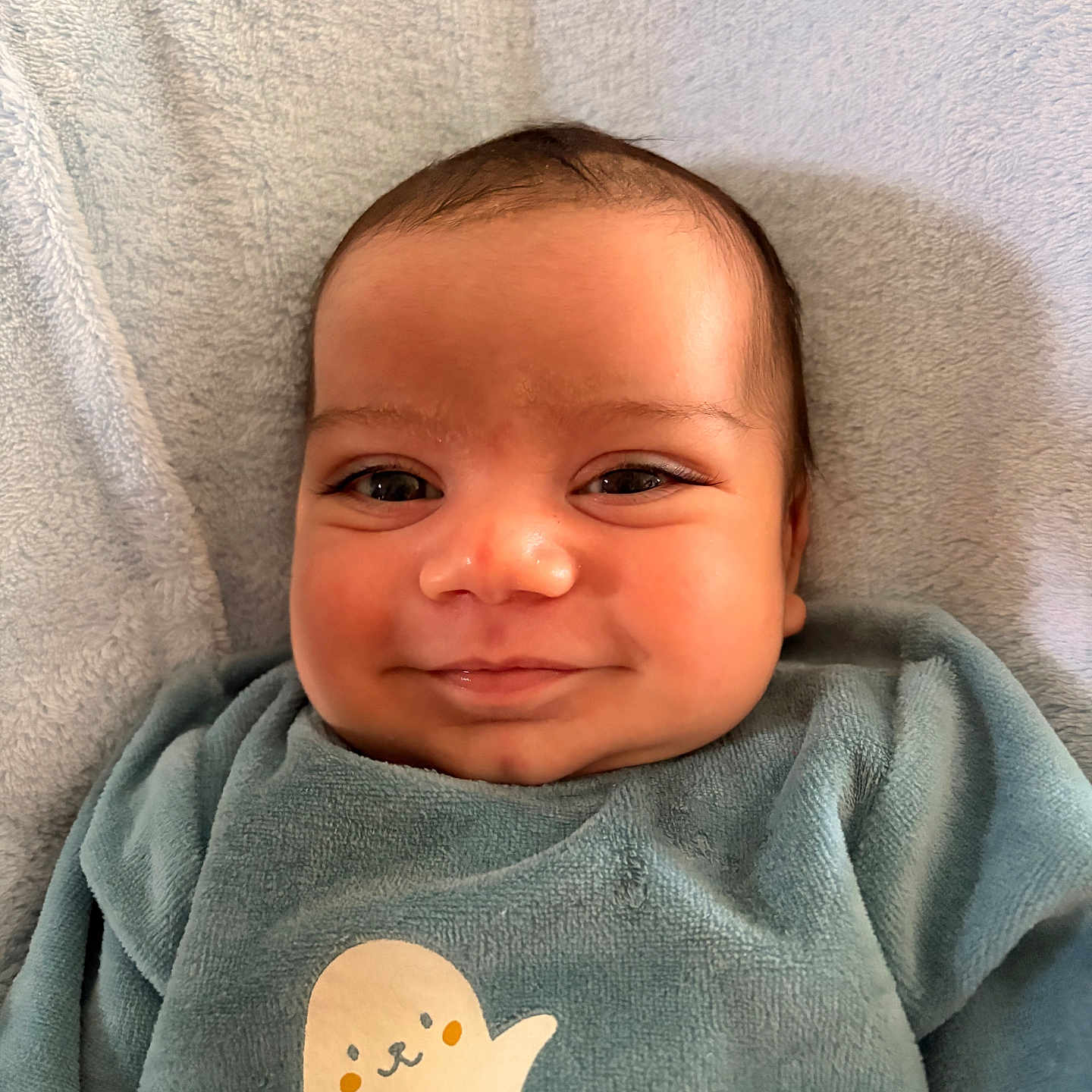 Egor participe au concours pour gagner de l'argent avec cette photo : baby, blanket, cheeks, closeup, clothing, cute, eyes, face, happy, indoor, infant, lying_down, onesie, portrait, seal_print, skin, smile, soft_texture, toddler, towel