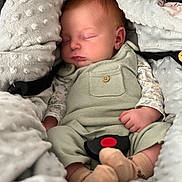 Jade a rejoint le concours — aidez-le/la à gagner de superbes lots ! baby, newborn, sleeping, blanket, car_seat, buckle, onesie, socks, overalls, soft_texture, cozy, portrait, closeup, hand, cheek, lips, hair, fabric, button, peaceful