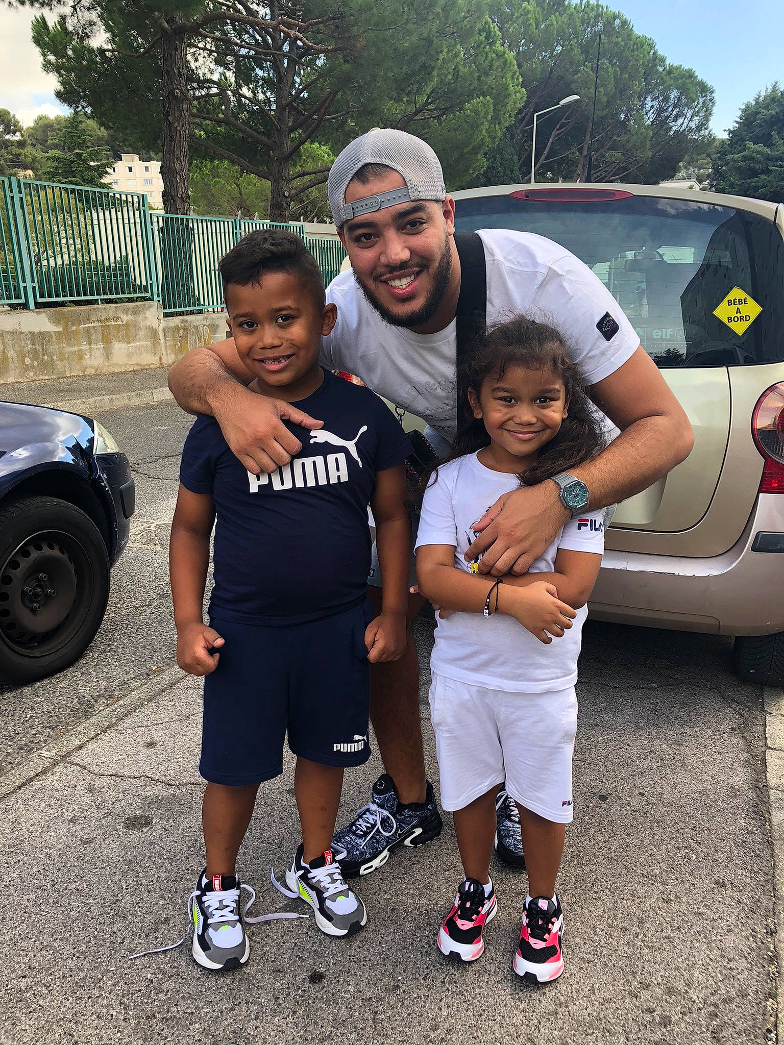 Sanaë a rejoint le concours — aidez-le/la à gagner de superbes lots ! asphalt, automotive_design, automotive_exterior, automotive_lighting, automotive_tire, car, footwear, headwear, joy, land_vehicle, motor_vehicle, parking, person, shorts, smile, sneakers, t_shirt, tire, toddler, tree