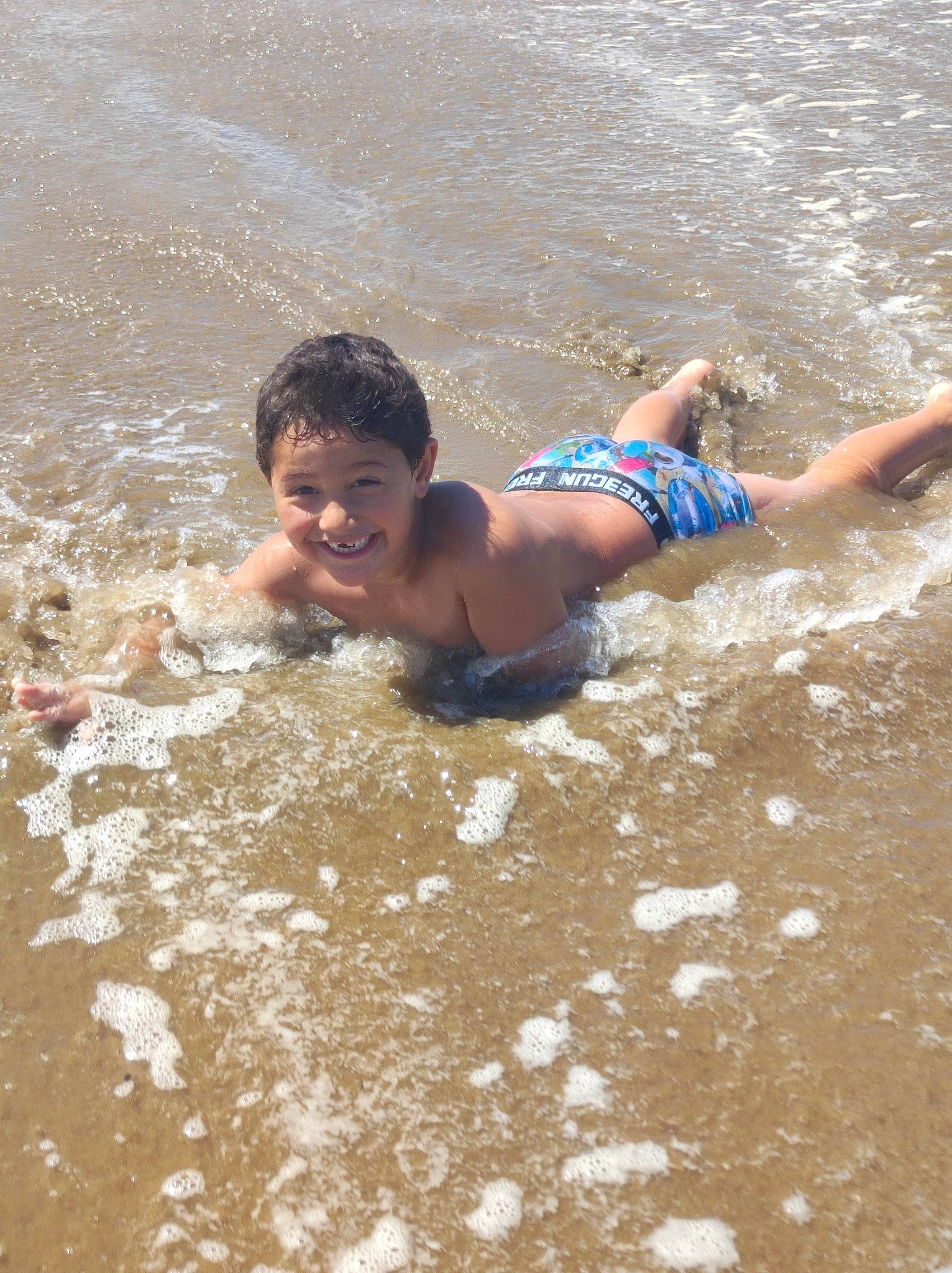 Samy a rejoint le concours — aidez-le/la à gagner de superbes lots ! barechested, barefoot, bathing, beach, chest, face, fun, hair, happy, head, joy, leisure, people_on_beach, person, recreation, sand, smile, summer, swimwear, toddler