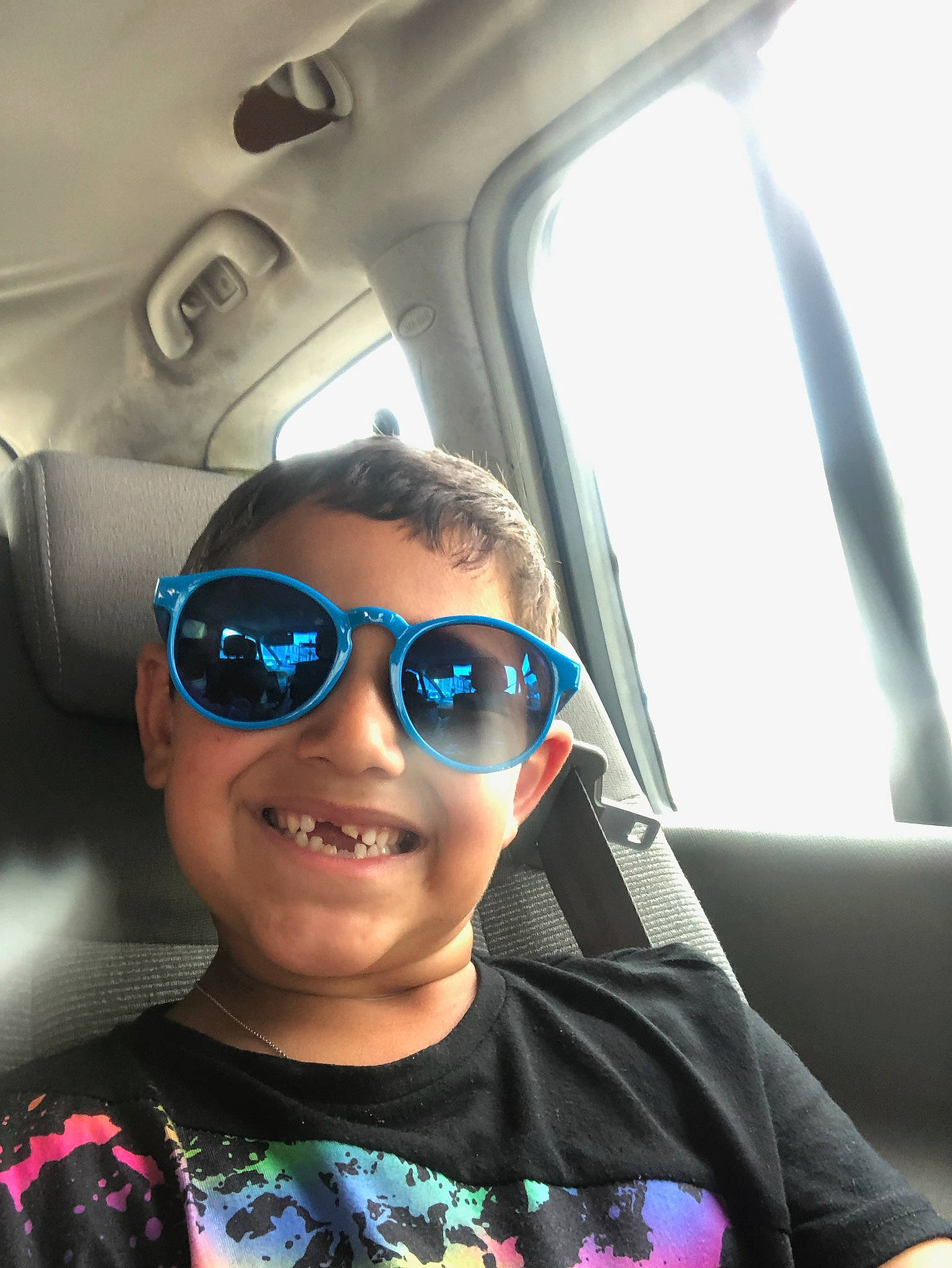 Samy a rejoint le concours — aidez-le/la à gagner de superbes lots ! automotive_design, car_seat, chin, cool, eyewear, face, glasses, goggles, hair, happy, head_restraint, joy, person, skin, smile, sunglasses, toddler, travel, vehicle, vision_care