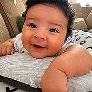 Ezra joined the competition — help win amazing prizes! baby, smiling, face, cute, child, infant, pillow, couch, indoor, happy, skin, hair, eyes, hand, arm, furniture, home, cozy, portrait, closeup