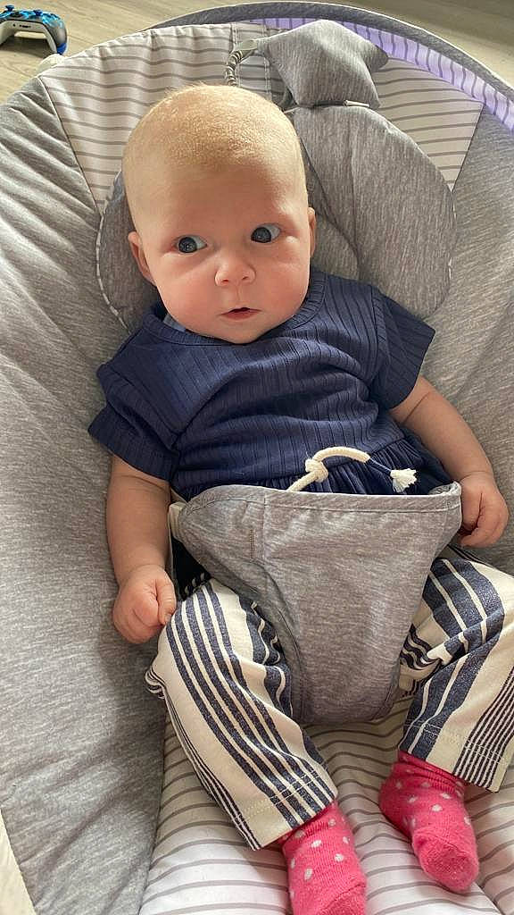 Harper Rose is registered to the contest to win money with this photo: baby, baby_products, baby_toddler_clothing, bag, chair, cheek, child, comfort, flooring, foot, human_leg, lap, linens, person, room, sandal, sitting, sleeve, sock, toddler