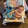 Aliyah joined the competition — help win amazing prizes! baby, plush_toy, stitch, blanket, couch, smiling, infant, soft_toy, child, cute, happy, indoors, seated, person, cozy, small_child, toddler, fabric, hand, portrait