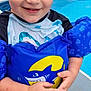 child, boy, pool, floatation_device, swimwear, water_shoes, shark, smiling, wet_hair, outdoor, summer, blue, red, splash, playful, happy, person, swimming, fun, water