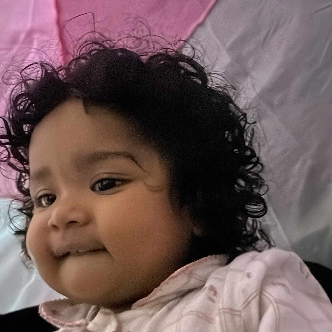 Japnaaz joined the competition — help win amazing prizes! baby, casual_clothing, child, close_up, curly_hair, cute, expression, face, hand, indoor, jacket, person, pink_background, portrait, smile, soft_light, toddler, warm_colors, white_background, young_child