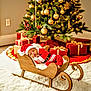 baby, christmas, santa_claus, sleigh, sleeping, holiday, decorations, presents, tree, ornaments, red_clothing, wooden, indoor, festive, gift_wrap, cozy, seasonal, holiday_spirit, cute, infant