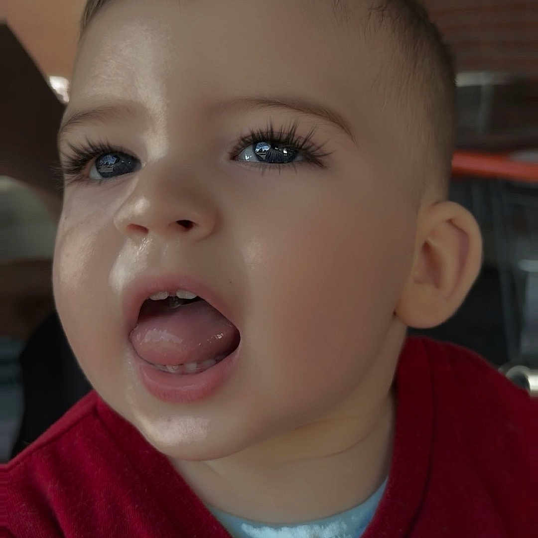 Tiago participe au concours pour gagner de l'argent avec cette photo : baby, child, close_up, clothing, cute, ear, expression, eyelashes, face, hair, indoor, mouth, nose, person, portrait, red_shirt, skin, toddler, tongue_out, young_child