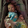 baby, blanket, blue_toy, child, clothing, comfort, cute, fabric, face, happy, indoor, infant, lion_king, person, plush_toy, portrait, seated, smiling, stroller, young_child