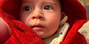 Tiago participe au concours pour gagner de l'argent avec cette photo : apparel, baby, candid, child, closeup, cozy, curious, cute, expression, face, hood, indoor, indoors, infant, person, portrait, red_robe, soft_light, warm_clothing, young_child