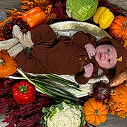 Greyson joined the competition — help win amazing prizes! baby, infant, autumn, pumpkin, vegetables, leafy_greens, cauliflower, red_pepper, yellow_pepper, orange_pumpkin, sweet_potato, onion, green_onion, fall_leaves, brown_clothing, knitted_booties, wood_floor, festive, cozy, portrait