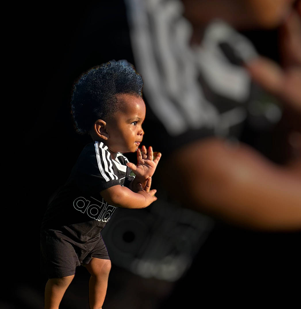 Cai is registered to the contest to win money with this photo: arm, baby_toddler_clothing, child, darkness, elbow, entertainment, event, fashion_design, flash_photography, fun, gesture, happy, human_leg, leg, performing_arts, person, sitting, sleeve, t_shirt, thumb