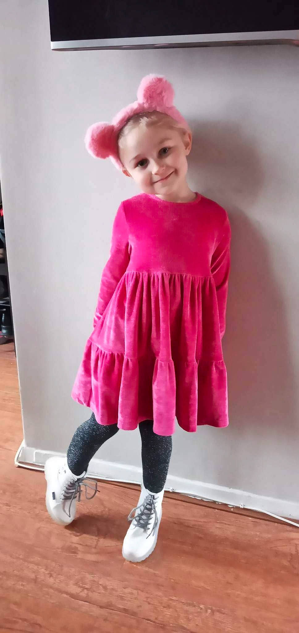 Emilia is registered to the contest to win money with this photo: baby_toddler_clothing, day_dress, electric_blue, face, fashion_design, human_leg, joint, joy, knee, magenta, one_piece_garment, person, pink, purple, sleeve, smile, sportswear, standing, t_shirt, thigh