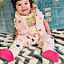 baby, child, smiling, curly_hair, sitting, blanket, heart_pattern, pink_socks, jacket, tshirt, jungle_cat, colorful, happy, indoors, cozy, cute, portrait, infant, soft_texture, playful