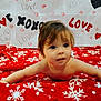 baby, child, infant, red_blanket, snowflake_pattern, love_text, xoxo_text, lipstick_kiss, cute, curious, toddler, indoors, portrait, face, skin, expression, blanket, holiday_theme, background, playful