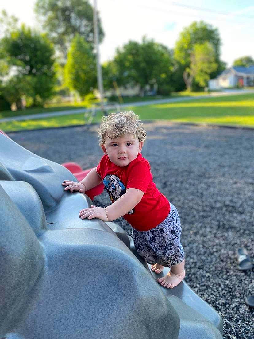 Damain is registered to the contest to win money with this photo: automotive_tire, grass, happy, leaf, leg, leisure, mammal, morning, motor_vehicle, outdoor_play_equipment, people_in_nature, person, plant, recreation, summer, sunlight, t_shirt, toddler, tree, vertebrate