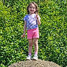 casual_clothing, child, daylight, gravel, greenery, happy, nature, outdoor, peace_sign, playful, portrait, shoes, shorts, smiling, socks, standing, summer, sunny, tshirt, young