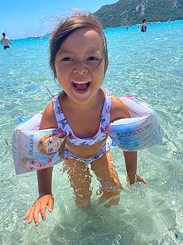 Milla a rejoint le concours — aidez-le/la à gagner de superbes lots ! aqua, azure, bathing, beach, blue, fun, happy, lake, leisure, muscle, outdoor_recreation, people_on_beach, person, personal_protective_equipment, recreation, sky, smile, summer, swimwear, toddler