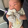 Malachi is registered to the contest to win money with this photo: adorable, baby, caregiver, child, close_up, clothing, face, giraffe, hand, held, indoor, infant, mitten, onesie, pacifier, portrait, sitting, sleepy, soft_lighting, vehicle