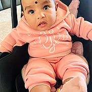 Laya joined the competition — help win amazing prizes! baby, infant, child, pink_clothing, car_seat, cute, soft_lighting, indoor, portrait, sitting, face, eyes, sock, hoodie, apparel, adorable, young_child, person, cozy, black_dot