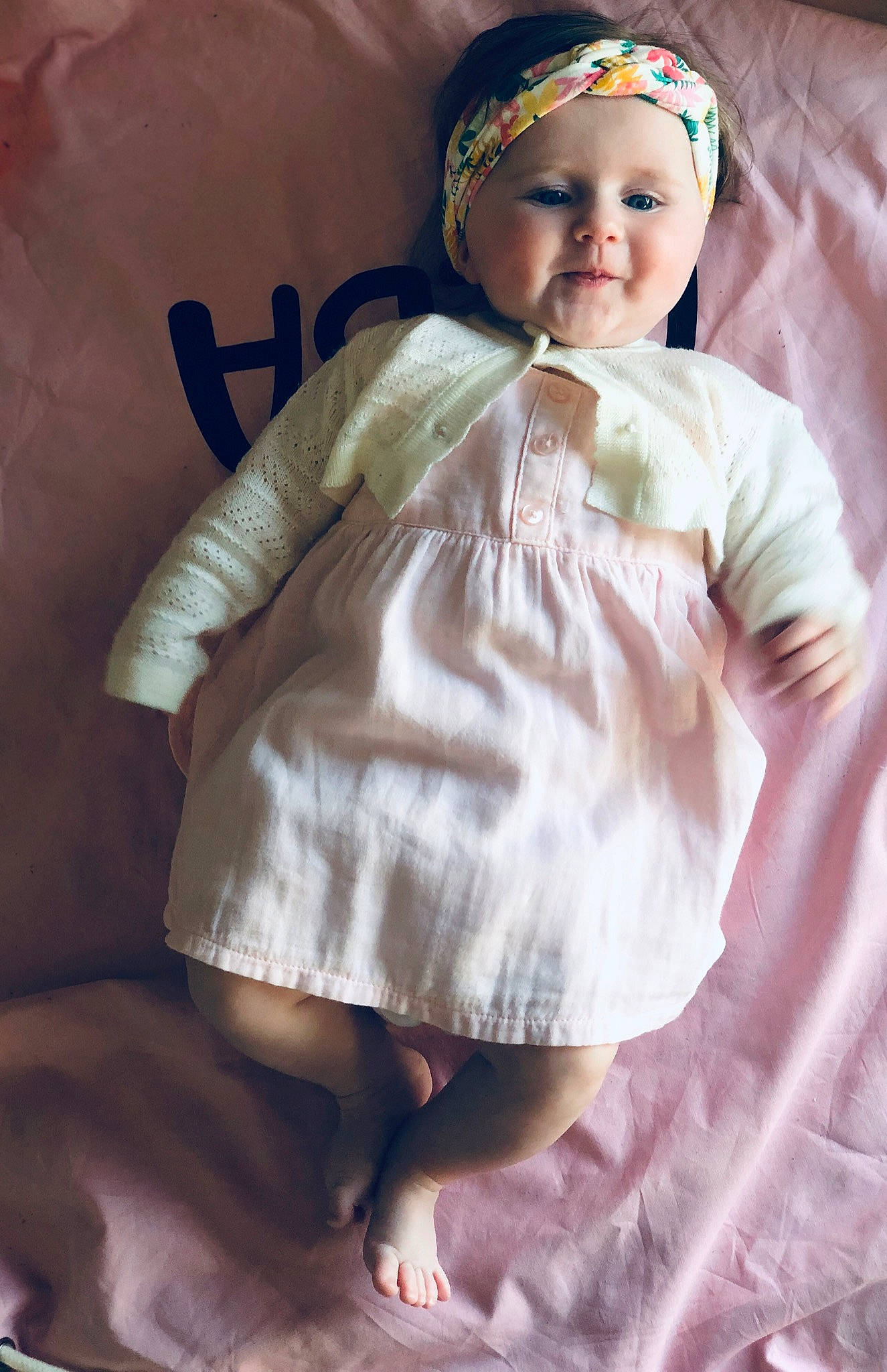 Alba participe au concours pour gagner de l'argent avec cette photo : baby, baby_toddler_clothing, cap, child, day_dress, dress, fashion_accessory, happy, headpiece, headwear, linens, lip, pattern, peach, person, pink, sitting, skin, sleeve, smile