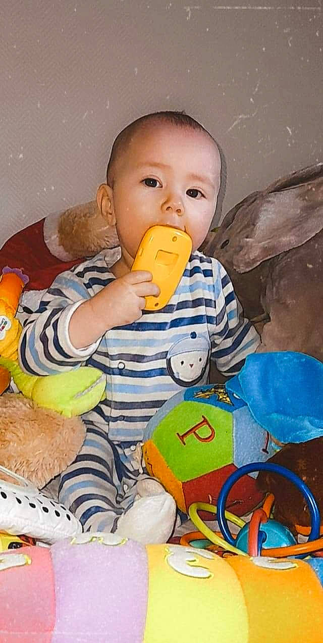 Menzo a rejoint le concours — aidez-le/la à gagner de superbes lots ! baby, baby_products, baby_toddler_clothing, baby_toys, cheek, child, drinkware, fun, happy, mouth, orange, organ, person, plastic, plastic_bottle, product, room, sitting, skin, toddler