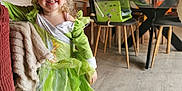 Azélïa a rejoint le concours — aidez-le/la à gagner de superbes lots ! child, girl, smiling, costume, green_dress, living_room, furniture, blanket, couch, wood_floor, chair, happy, indoor, person, curly_hair, home_decor, table, toy, socks, photography