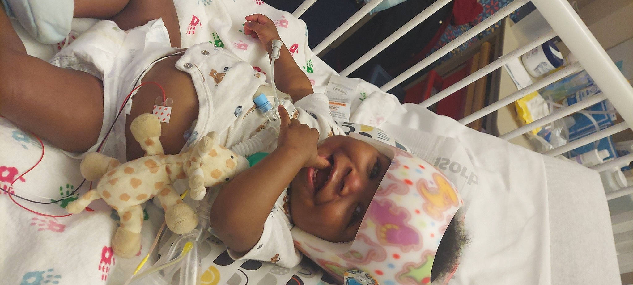 Eddie is registered to the contest to win money with this photo: baby, baby_products, baby_safety, baby_toddler_clothing, bed, bedding, bedtime, child, childbirth, comfort, comfort_food, head, headwear, hospital, human_body, linens, person, room, service, skin