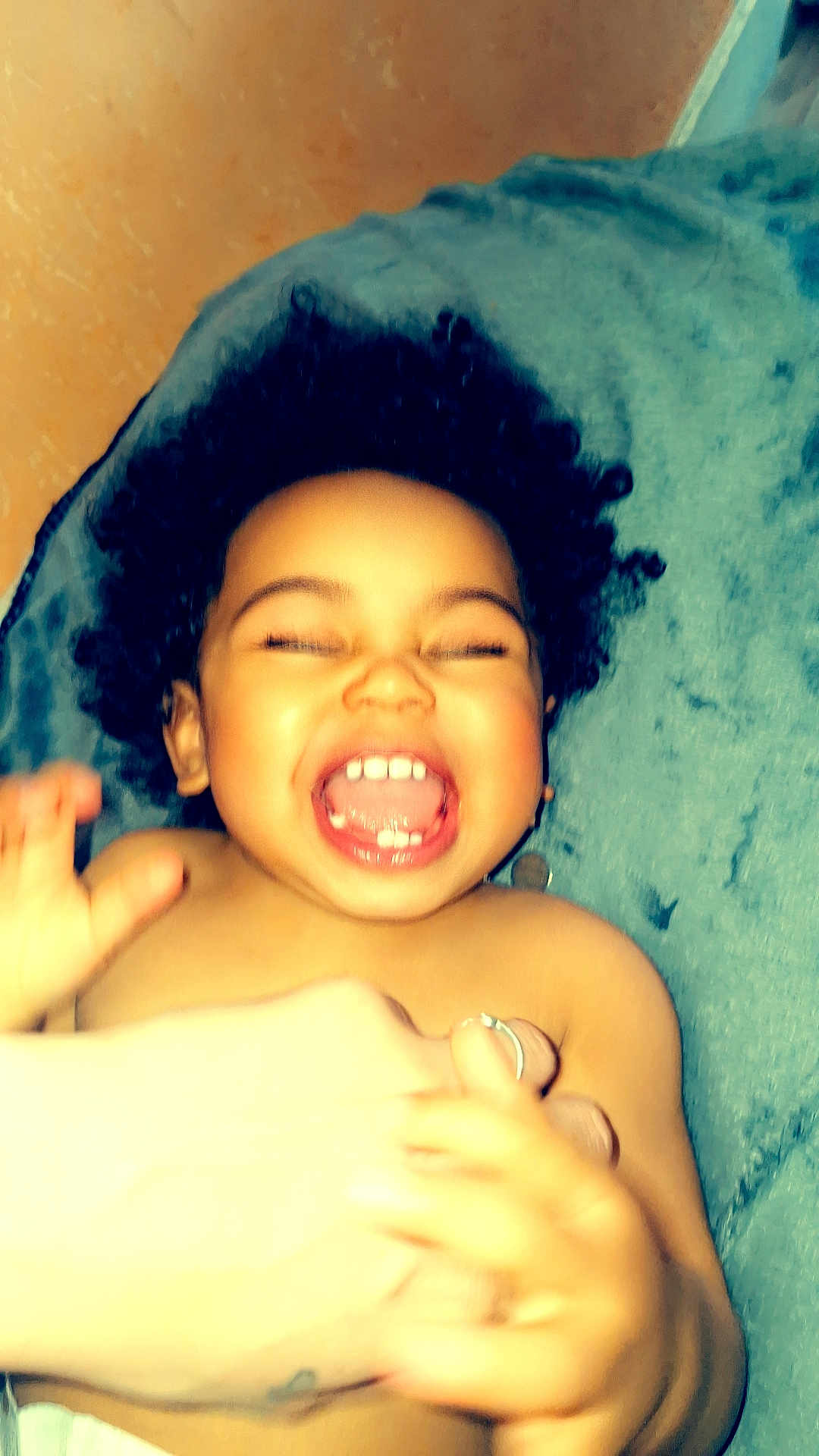 Naylow a rejoint le concours — aidez-le/la à gagner de superbes lots ! toddler, child, laughing, curly_hair, hands, blanket, happy, smile, skin, person, indoor, playful, baby, expression, joy, human, head, mouth, teeth, cheerful