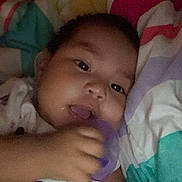 Amaria joined the competition — help win amazing prizes! baby, child, face, hand, blanket, colorful, indoor, infant, person, cute, young, sleeping, resting, soft, comfort, pajamas, toy, closeup, portrait, relaxed