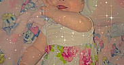 Athena is registered to the contest to win money with this photo: baby, bedspread, blanket, cartoon_characters, child, cute, face, floral_pattern, happy, indoors, infant, lying_down, person, pillow, pink, sleepwear, smiling, soft_toys, sparkles, toddler